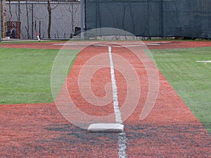 Looking down the foul line from third base to the batter box of a turf baseball field