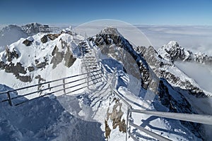 Zasnežený vyhliadkový chodník cez hrebeň Vysokých Tatier v zime, štít Lomnický štít, Slovensko