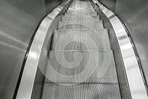 Looking down looping stainless steel mechanical moving escalator