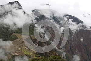 Looking down at Machu Picchu and the Vilcabamba Mountain Range through the clouds from atop Huayna Picchu