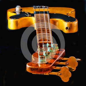 Looking Down the Neck of a Vintage Worn Electric Bass Guitar - View is strings, frets, body, knobs