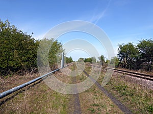 Looking down rail line with adjacent gas pipe and expansion loop photo