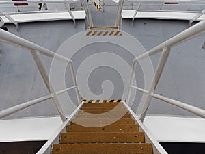 Looking down a series of stairways between decks of a Vessel with its Yellow anti skid plates