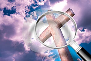 Looking for faith - concept image with a magnifying glass in front of a Christian cross