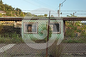 Looking through a fence at an abandoned security building