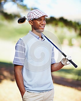 Looking forward to a round of golf. a confident african american golf player holding a driver over his shoulder.