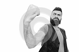 Looking frighteningly as a muscular man. Bearded muscular man shaking fist. Brutal hipster flexing his arm with muscular photo