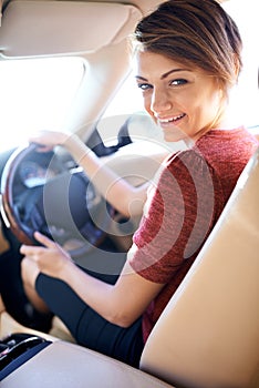 Looking good in her new ride. a beautiful young woman driving a luxury car.