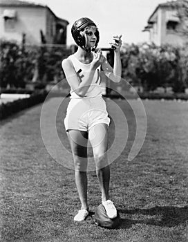 Looking good for the team, a young woman in a football helmet looking into a mirror and putting on make up