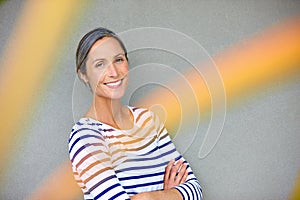 Looking great for her age. Portrait of an attractive mature woman in casualwear standing against a gray wall.