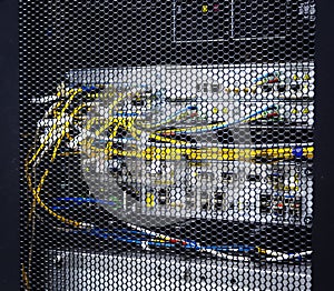 Looking through honeycomb pattern doors inside modern big data server rack in data center with network servers hardware and