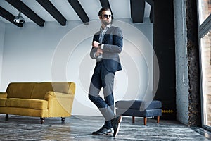 Looking just perfect. Full length portrait of young stylish businessman in suit who is standing in a modern office