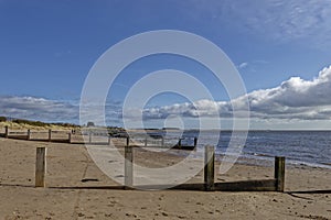 Looking north between the wooden Groynes of Monifieth beach towards Barry Buddon