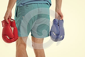 Looking for opponent. Man in shorts carries two pairs boxing gloves rear view isolated white background. Equipment