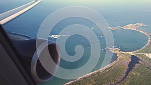 Looking out the airplane window at the engine and wing while landing in San Juan Puerto Rico`s beaches and coastline