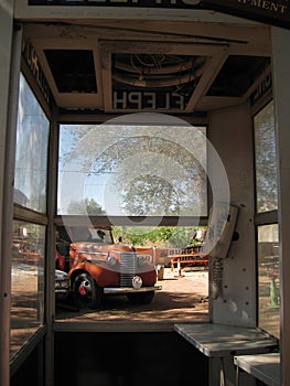 Looking out from an old phone booth at vintage cars