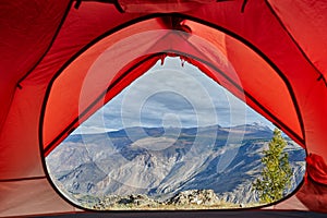 Looking out of open tent door upon calm river.