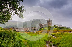 Looking out to Eilean Donan Castle, where three sea lochs meet, Loch Duich, Loch Long and Loch Alsh, on an overcast day in the Sco