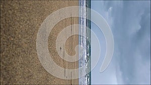 Looking out to the sea from the beach. Waves crashing on the shore, water going back and forth. Calm waves hitting the beach sand