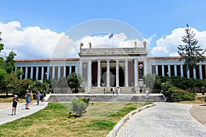 Looking outside at the front of the world famous National Archaeological Museum in Athens, Greece.  Several visitors are walking t