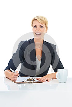 Looking over the documents with a cup of coffee. Portrait of a young businesswoman drinking coffee while filling in some