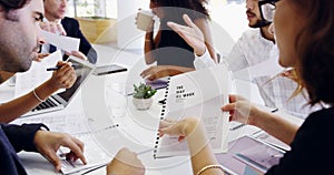 Looking over the paperwork. Cropped shot of a group of businesspeople sitting around the boardroom table during a