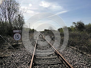 Looking down railway line with sign and turnoff photo