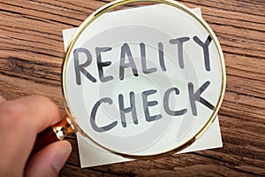 Looking At Reality Check Word Through Magnifying Glass