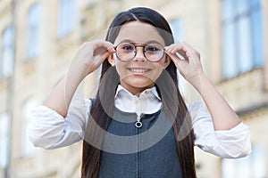 Looking to future. Happy kid fix eyeglasses outdoors. Eye sight development. Child vision. Back to school eye sight test