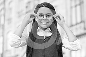 Looking to future. Happy kid fix eyeglasses outdoors. Eye sight development. Child vision. Back to school eye sight test