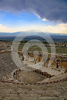 Looking towards the stage of the theatre, Hierapolis with dark storm clouds on the horizon