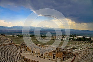 Looking towards the stage of the theatre, Hierapolis with dark storm clouds on the horizon