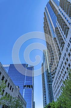 Looking up at apartments with modern geometric architecture against blue sky