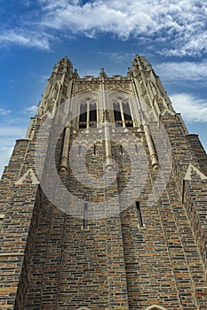 Looking up at the belltower of the Duke University Chapel on a day with a blue sky and fluffy clouds