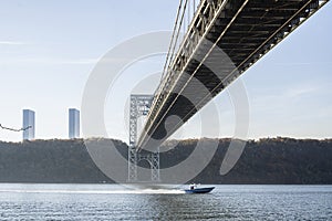 Looking up at the George Washington Bridge with a motorbike passing by on Hudson River