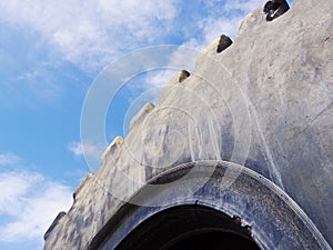 Looking up at a haul truck tire against a blue sky.