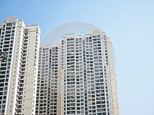 Looking up high-rise apartment complex condominium buildings with open balcony hanging clothes, clear blue sky in Hanoi, Vietnam,