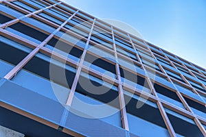 Looking up at a modern building in the city with cloudless blue sky background