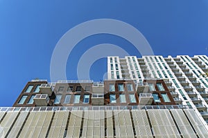 Looking up at modern luxury apartment against vibrant cloudless blue sky