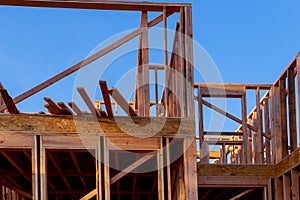 Looking up new construction beams under a clear blue sky with sunlight
