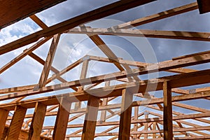 Looking up new construction beams under a clear blue sky with sunlight
