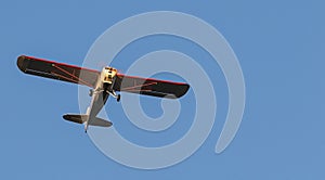 Looking up at small single prop plane with deep blue sky