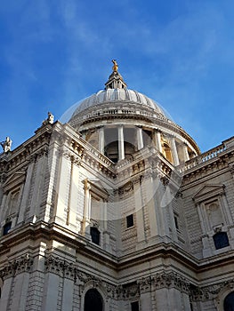 Looking up at St Pauls Catheral in sunlight and blue sky the dome rising up
