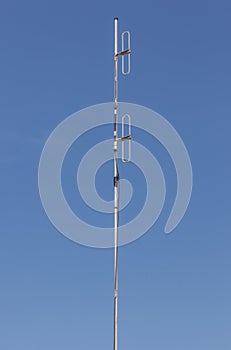 Looking up the telecommunication dipole antenna with blue sky ba