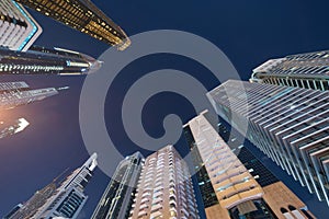 Looking up to high-rise office buildings, skyscrapers, architectures in financial district. Smart urban city for business and