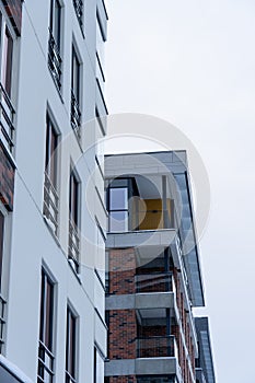 Looking up to modern new white and brown brick apartments building at Pille street during winter time. Tallinn, Estonia