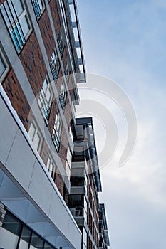 Looking up to modern new white and brown brick apartments building at Pille street during winter time. Tallinn, Estonia