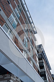 Looking up to modern new white and brown brick apartments building at Pille street during winter time. Tallinn, Estonia