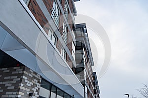 Looking up to modern new white and brown brick apartments building at Pille street during winter time. Tallinn, Estonia