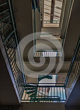 Looking up from under view upstairs walkway of an old apartment building